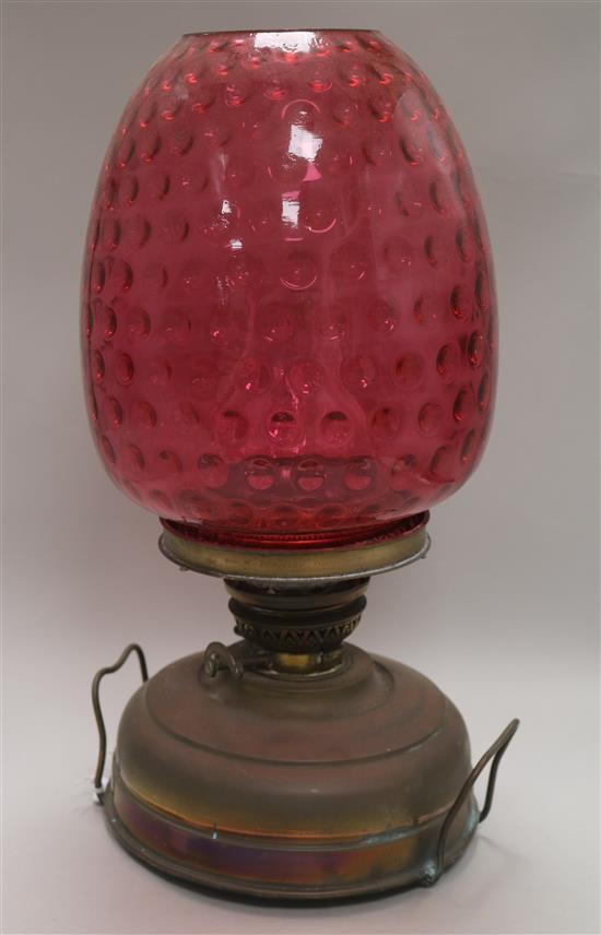 A Victorian brass oil lamp with ruby glass shade